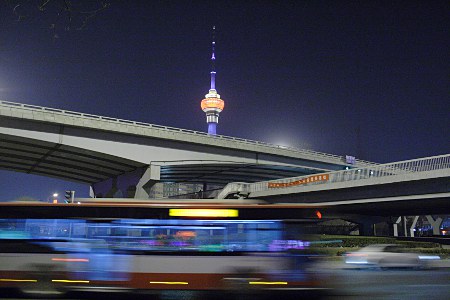 Hangtianqiao (Brücke) mit Fernsehturm im Hintergrund und verwaschenem Linienbus im Vordergrund