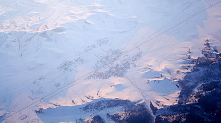 Siedlung in verschneiter Umgebung - Luftaufnahme