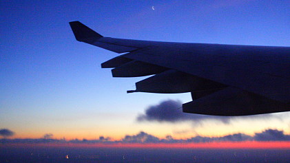 Blick aus dem Flugzeug auf das Abendrot zwischen Wolken