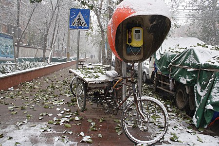 Rad und Telefonzelle im Schnee