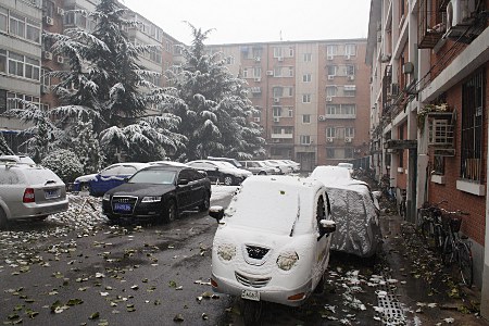 Verschneite Strae mit parkenden Fahrzeugen