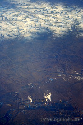 Kraftwerk im Vordergrund, dahinter Schneebedeckte Berge